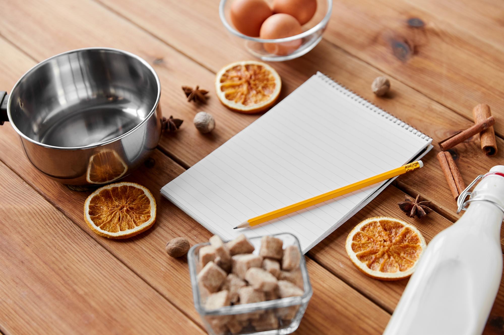 Notebook con ricette e tazze di ingredienti